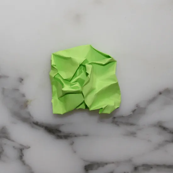 A crumpled green post-it note on marble — a visual joke about how your site looks when you forget to link your CSS stylesheet in the HTML head